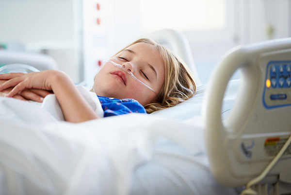 Ein Kind liegt in einem Krankenhausbett und schläft.